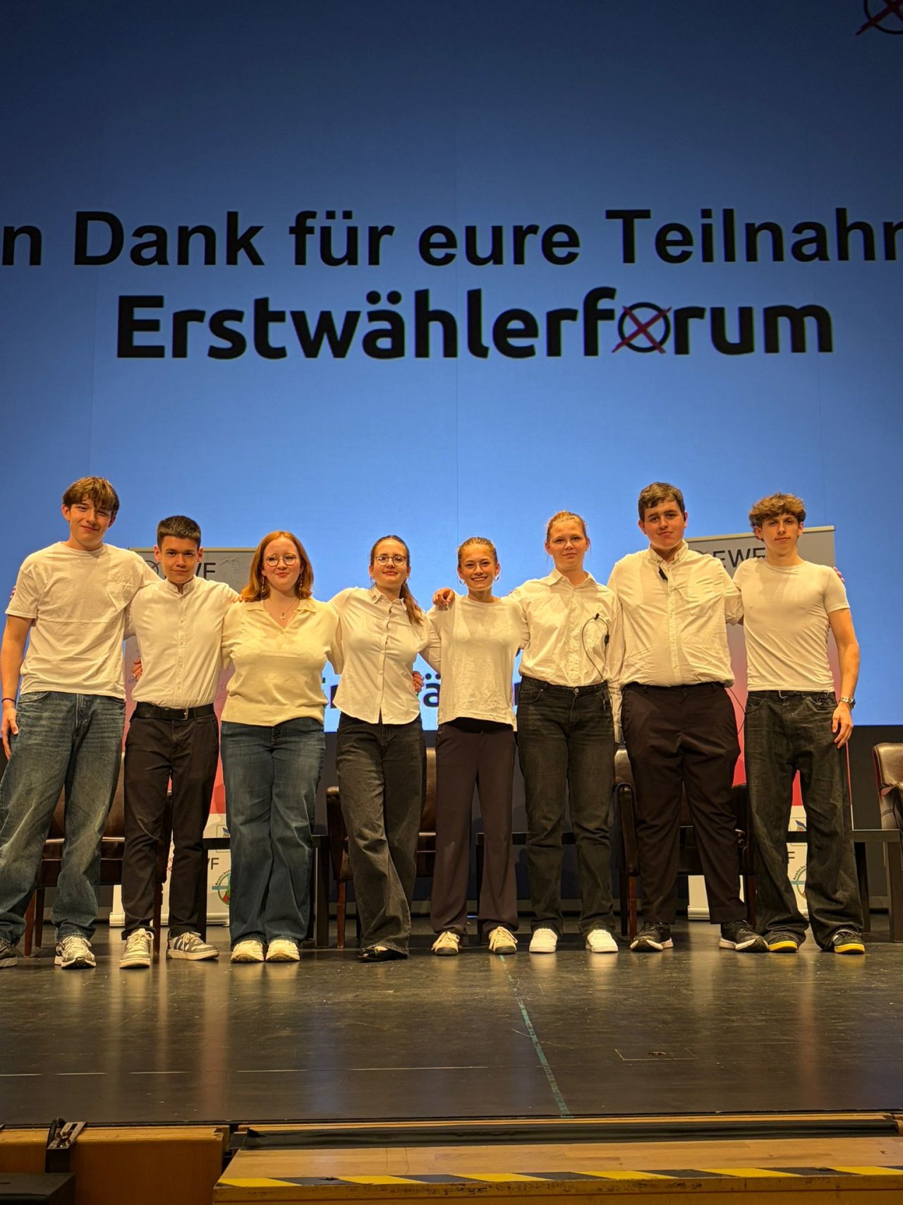 Gruppenfoto auf der Bühne vor der Abschlussfolie des Erstwählerforums.