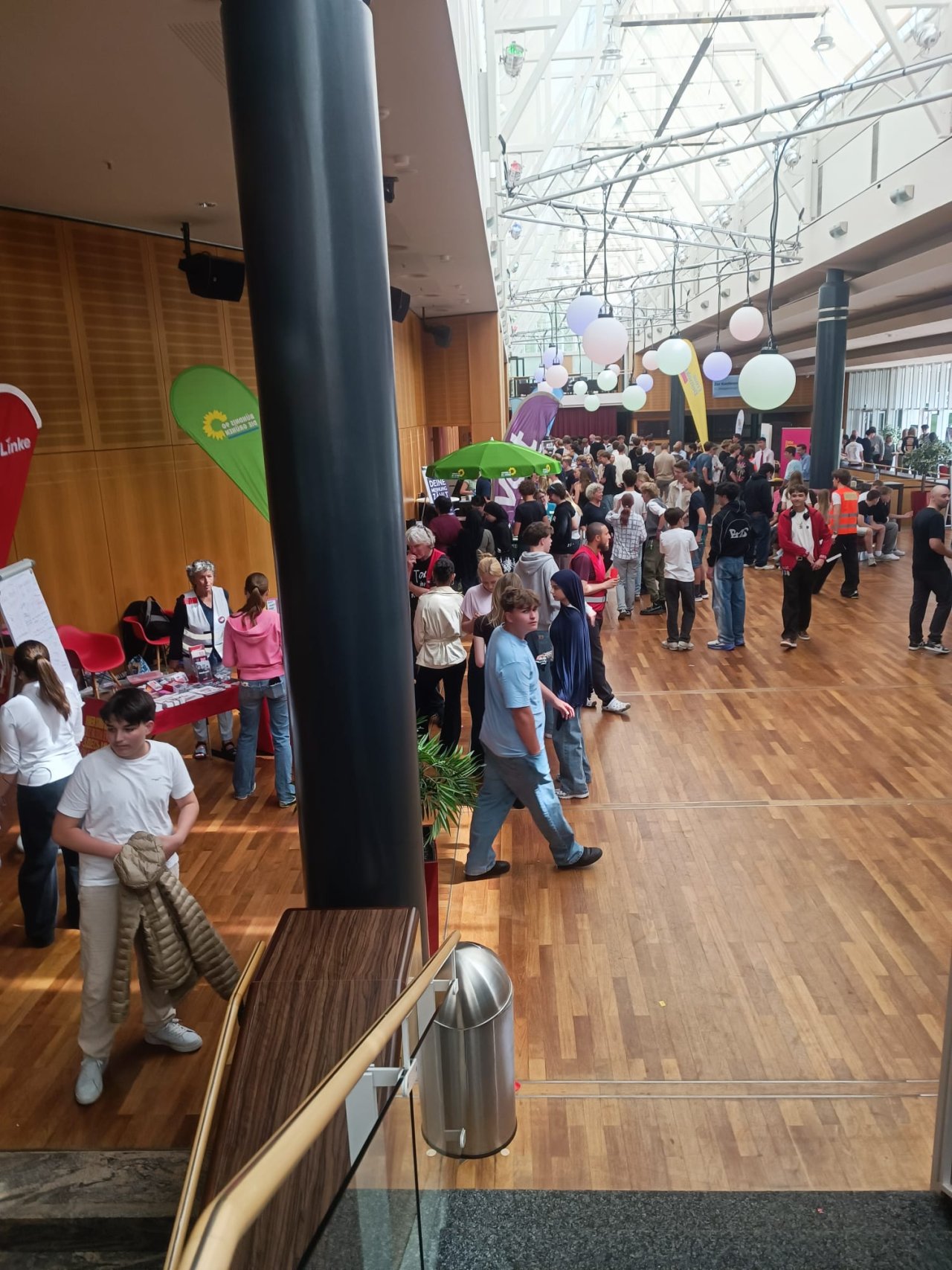 Besucherinnen und Besucher an den Informationsständen im Foyer.