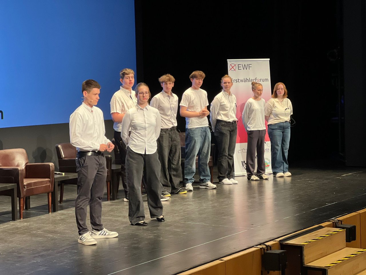 Gruppe in weißen Hemden auf der Bühne des Erstwählerforums.